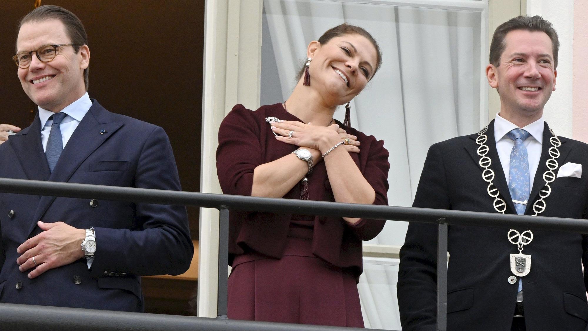 Prinzessin Victoria (m) und Prinz Daniel (l) von Schweden stehen auf dem Balkon des Rathauses mit dem Jan D. Oker-Blom, Bürgermeister von Lovisa.
