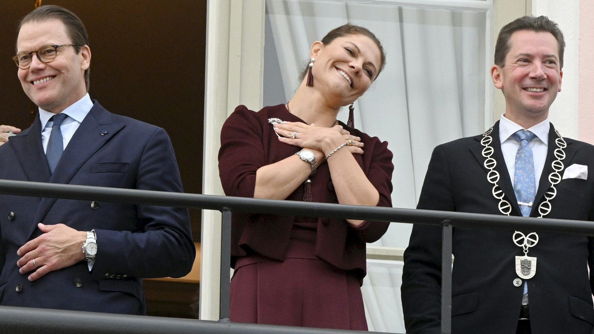 Prinzessin Victoria (m) und Prinz Daniel (l) von Schweden stehen auf dem Balkon des Rathauses mit dem Jan D. Oker-Blom, Bürgermeister von Lovisa.