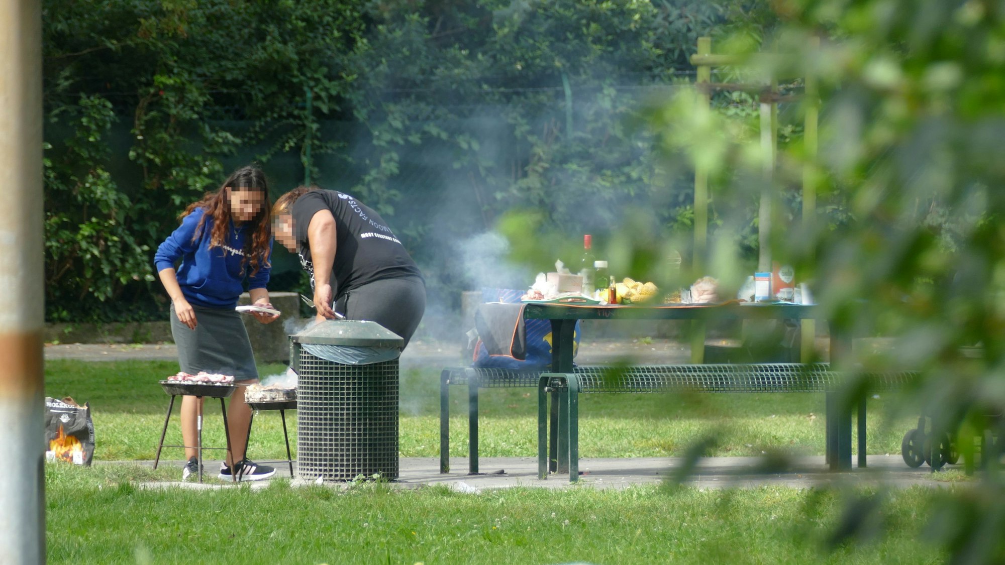 Zwei Frauen grillen in einem Park