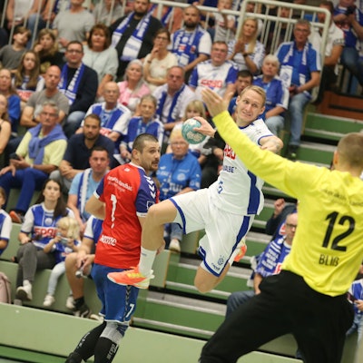Tilen Kodrin springt mit dem Ball in der rechten Hand auf den Ratinger Torhüter zu.