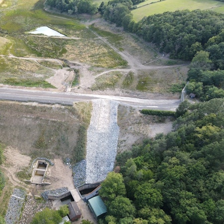 Das Bild zeigt die Steinbachtalsperre aus der Luft. Im Damm ist weiterhin ein großes Loch zu erkennen.