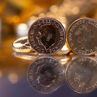 Goldbarren und Goldmünzen in unterschiedlicher Größe liegen beim Edelmetallhändler Pro Aurum in einem Tresor auf einem Tisch.