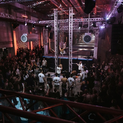 Ein Athlet absolviert einen Parcours, Menschen schauen ihm zu.