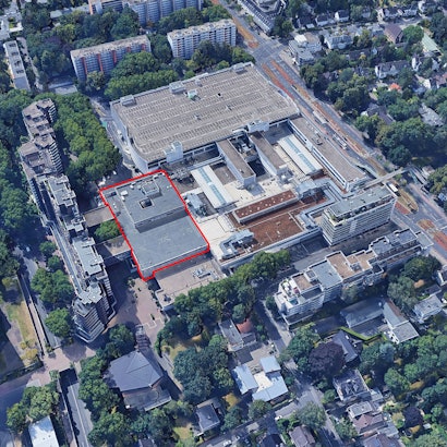 Das Einkaufszentrum Rhein-Center in Weiden an der Aachener Straße (rechts im Bild). Ein eigenständiger Gebäudeteil des Komplexes (rot hervorgehoben), in dem früher das Warenhaus Kaufhof beheimatet war, hat nun den Besitzer gewechselt.