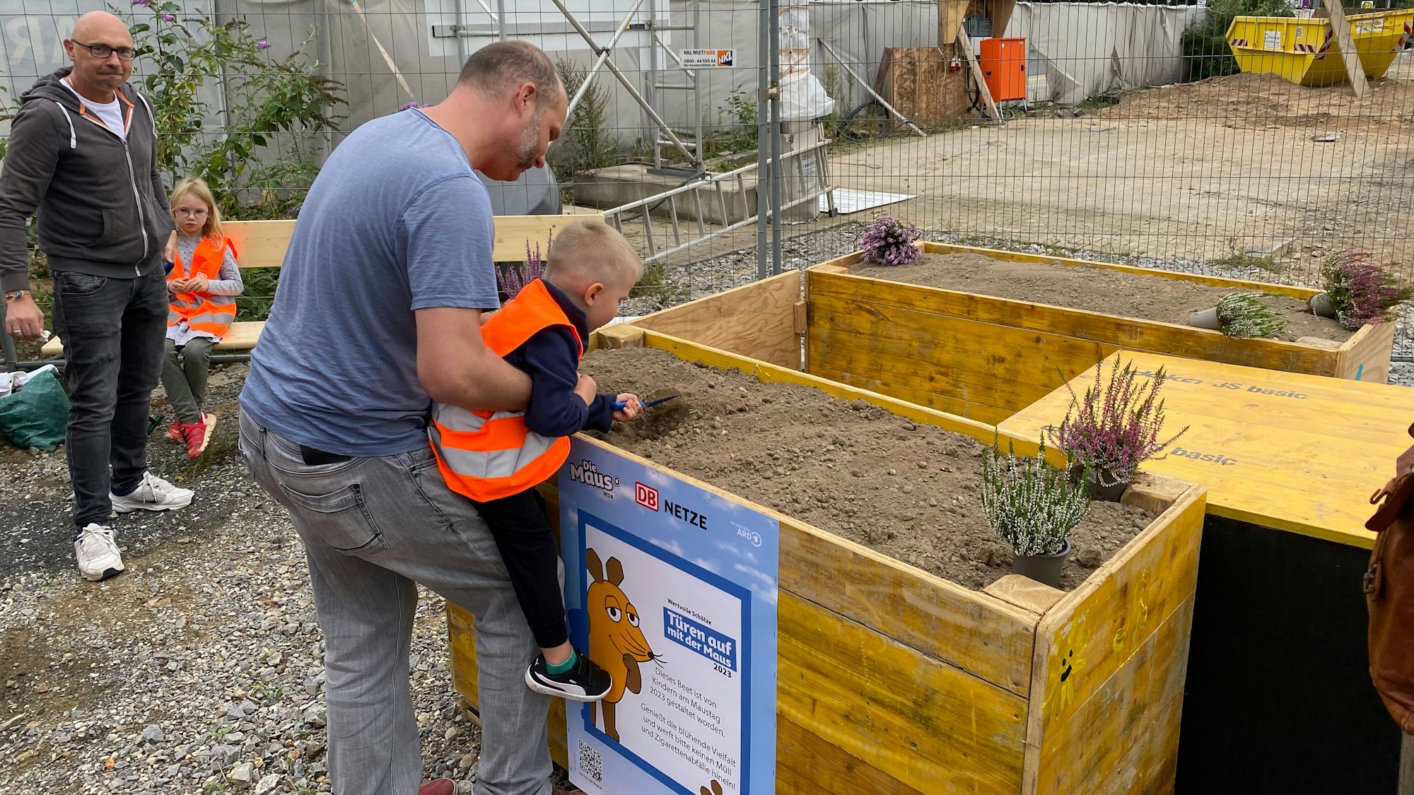 Ein Kind pflanzt etwas in einem Hochbeet.