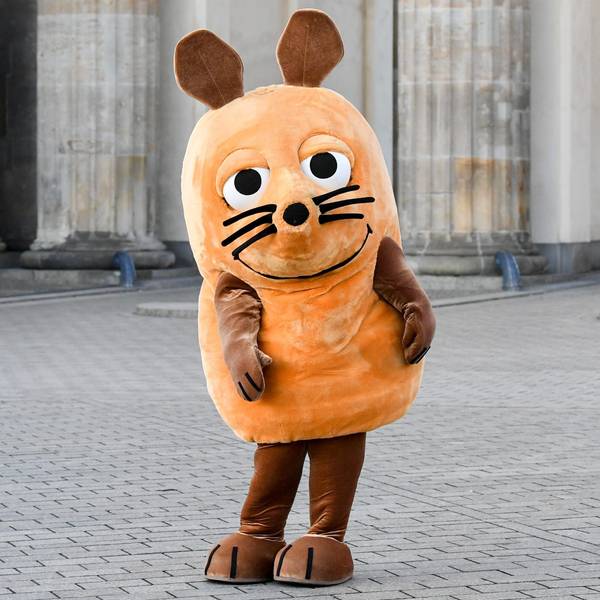 Eine „Maus“-Figur steht vor dem Brandenburger Tor.
