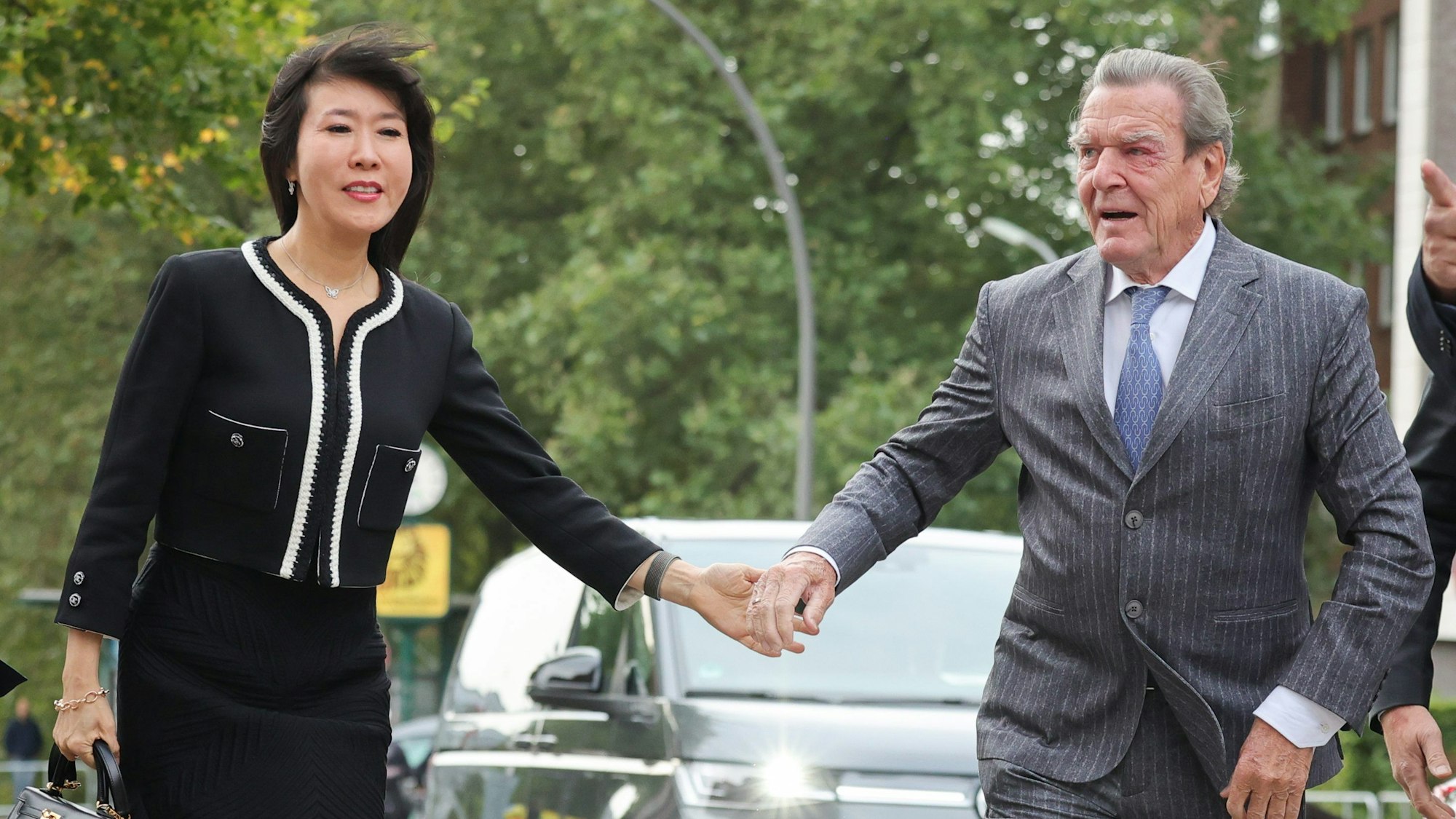 Der ehemalige Bundeskanzler Gerhard Schröder (r) und seine Frau So-yeon Schröder-Kim bei ihrer Ankunft vor der Hauptkirche St. Michaelis (Michel).
