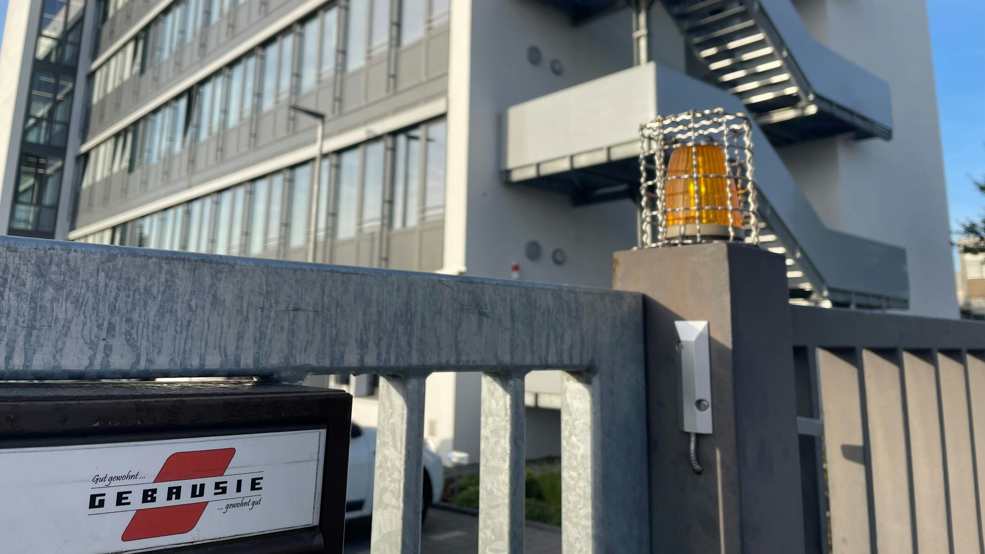 Zu sehen ist das Eingangstor der städtischen Wohnungsgesellschaft Gebausie. Im Hintergrund steht ein Gebäude.