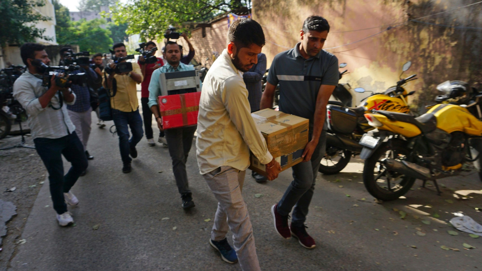 Neu Delhi: Sicherheitsbeamte tragen Kisten mit beschlagnahmtem Material nach einer Razzia im Büro von NewsClick.