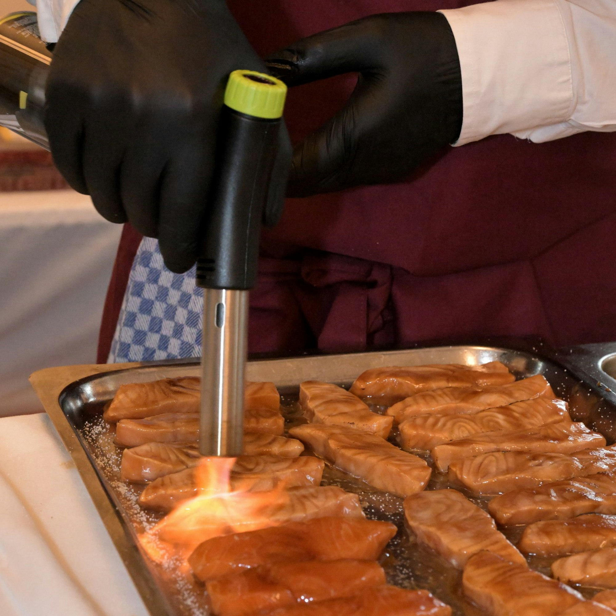 Lachs mit Teryaki-Ingwer-Algen wird geflämmt.