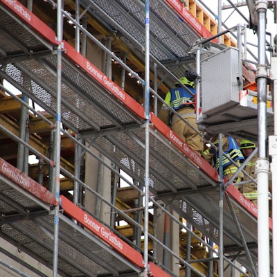 Auf der Baustelle des neuen Gerichtsgebäudes für die Cum-Ex-Prozesse ist ein 64 Jahre alter Bauarbeiter schwer verletzt worden. Feuerwehrmänner schieben ihn auf einer Schlleifkorbtrage auf den Korb des Teleskopmasts.