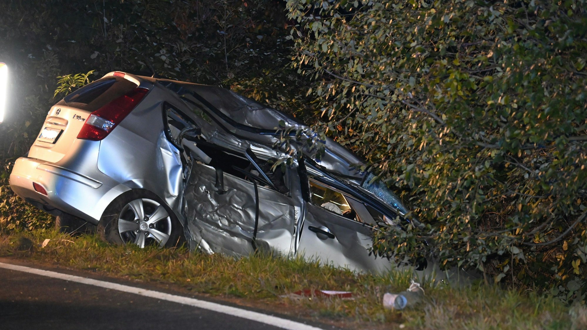 Das Bild zeigt einen silberfarbenen Wagen im Straßengraben.