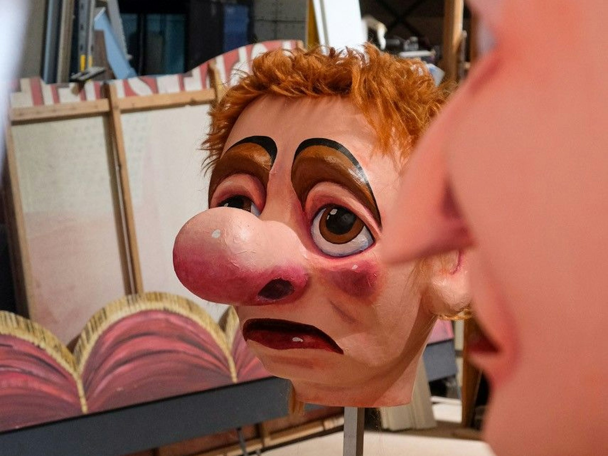 Der Kopf einer Figur mit einer großen Nase und rotem Haar.