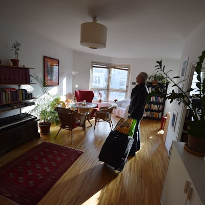 ARCHIV - ILLUSTRATION - Ein Tourist, der eine Übernachtung über das Onlineportal Airbnb gebucht hat, kommt am 07.11.2014 in Berlin mit seinem Koffer in der gemieteten Wohnung an. Online-Portale bieten individuelle Alternativen zur Pauschalreise. Auch in Sachsen-Anhalt wächst der Trend. Foto: Jens Kalaene/dpa (zu dpa-KORR lah "Zu Gast bei Fremden: Hotelalternativen werden beliebter im Land" vom 22.03.2015) +++ dpa-Bildfunk +++