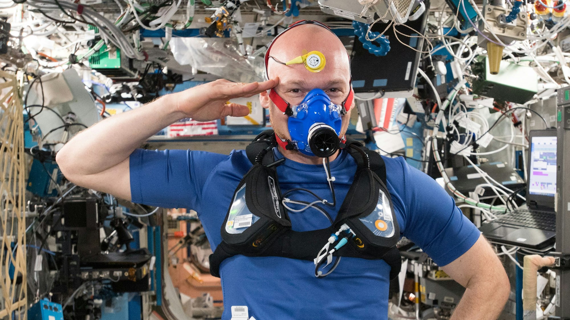 Alexander Gerst salutiert beim Selfie während einer anstrengenden Versuchsreihe zur Entwicklung neuer Textilien und Instrumente auf der Internationalen Weltraumstation ISS.