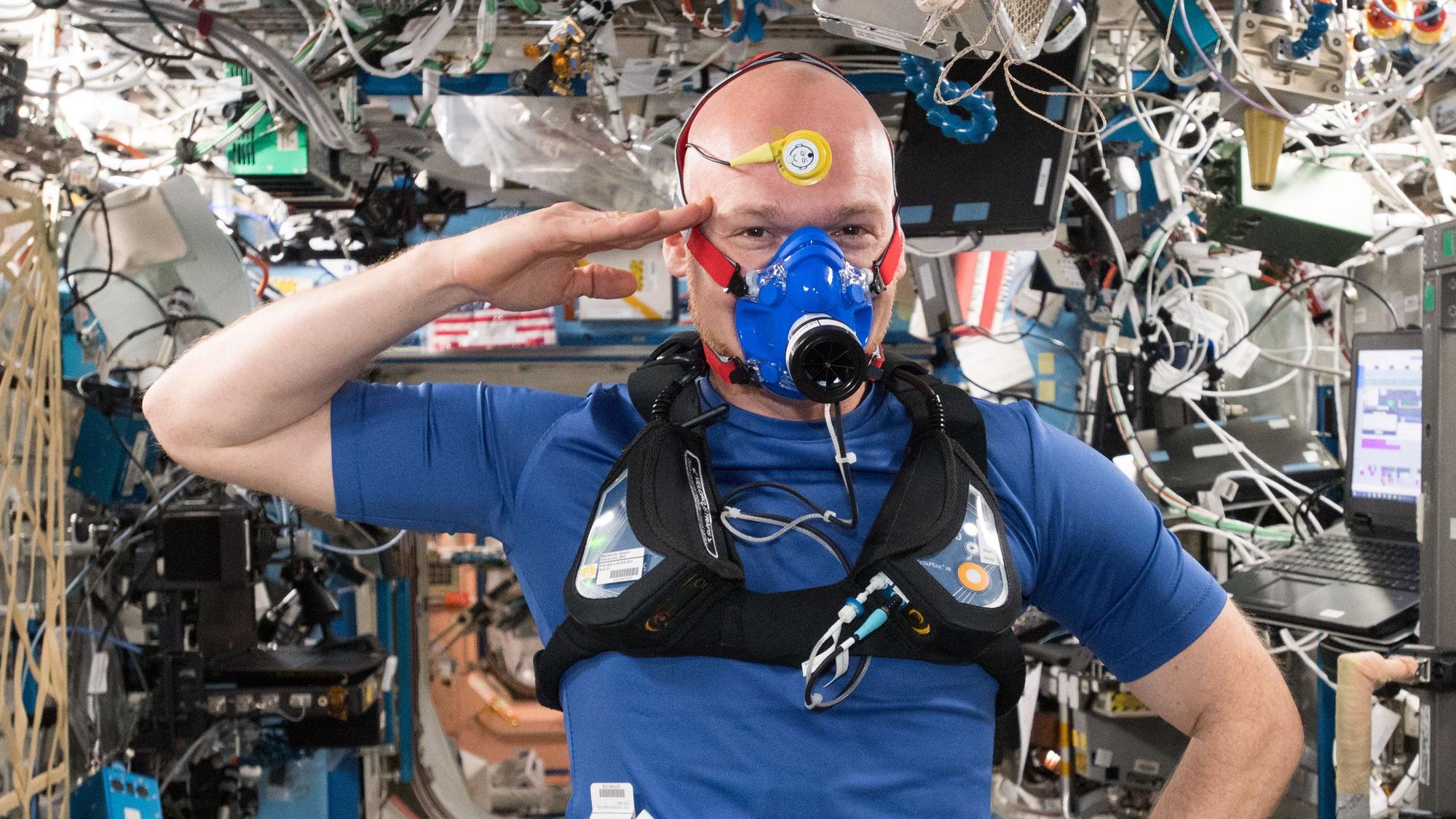 Alexander Gerst salutiert beim Selfie während einer anstrengenden Versuchsreihe zur Entwicklung neuer Textilien und Instrumente auf der Internationalen Weltraumstation ISS.