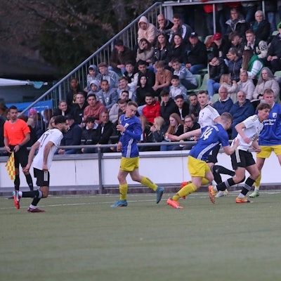 Vor einer gut gefüllten Zuschauertribüne möchte ein Nümbrechter einem Wiehler Fußballer den Ball abjagen..