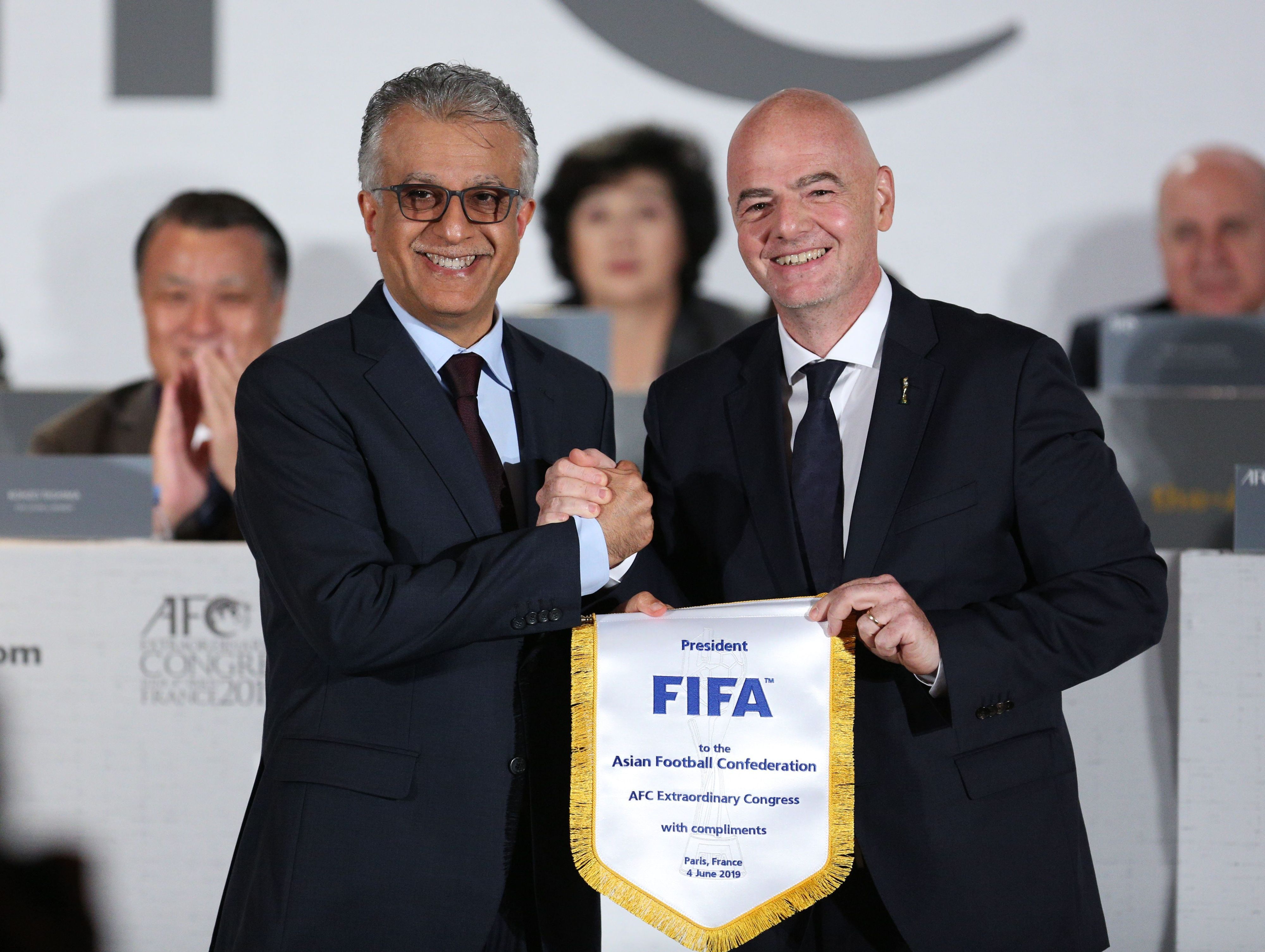 Gianni Infantino (r), Präsident des Weltfußballverbandes FIFA, hält einen Wimpel neben Salman bin Ibrahim al-Chalifa, Präsident der asiatischen Fußballkonföderation (AFC), bei einem außerordentlichen Kongress der AFC. Scheich Salman hat seine Unterstützung für die Bewerbung Saudi-Arabiens für die WM 2034 ausgedrückt.