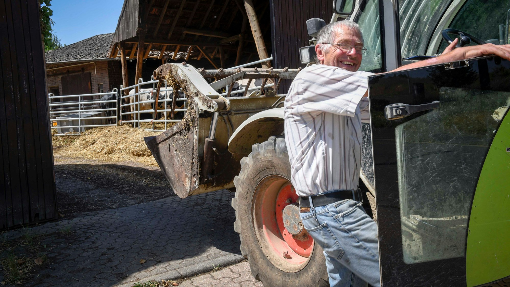 Heinrich Portz steigt auf seinem Hof von einem Traktor.