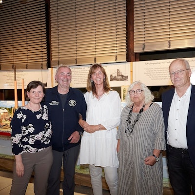Zwei Männer und drei Frauen, Petra Hansen (v.l.), Günter Nießen, Ela Rübenach, Donata Reinhard und Hans-Peter Schick, stehen in einem Raum des Mechernicher Bergbaumuseum vor einem Modell des Bleibergwerks, das es bis 1957 in der Stadt gab.