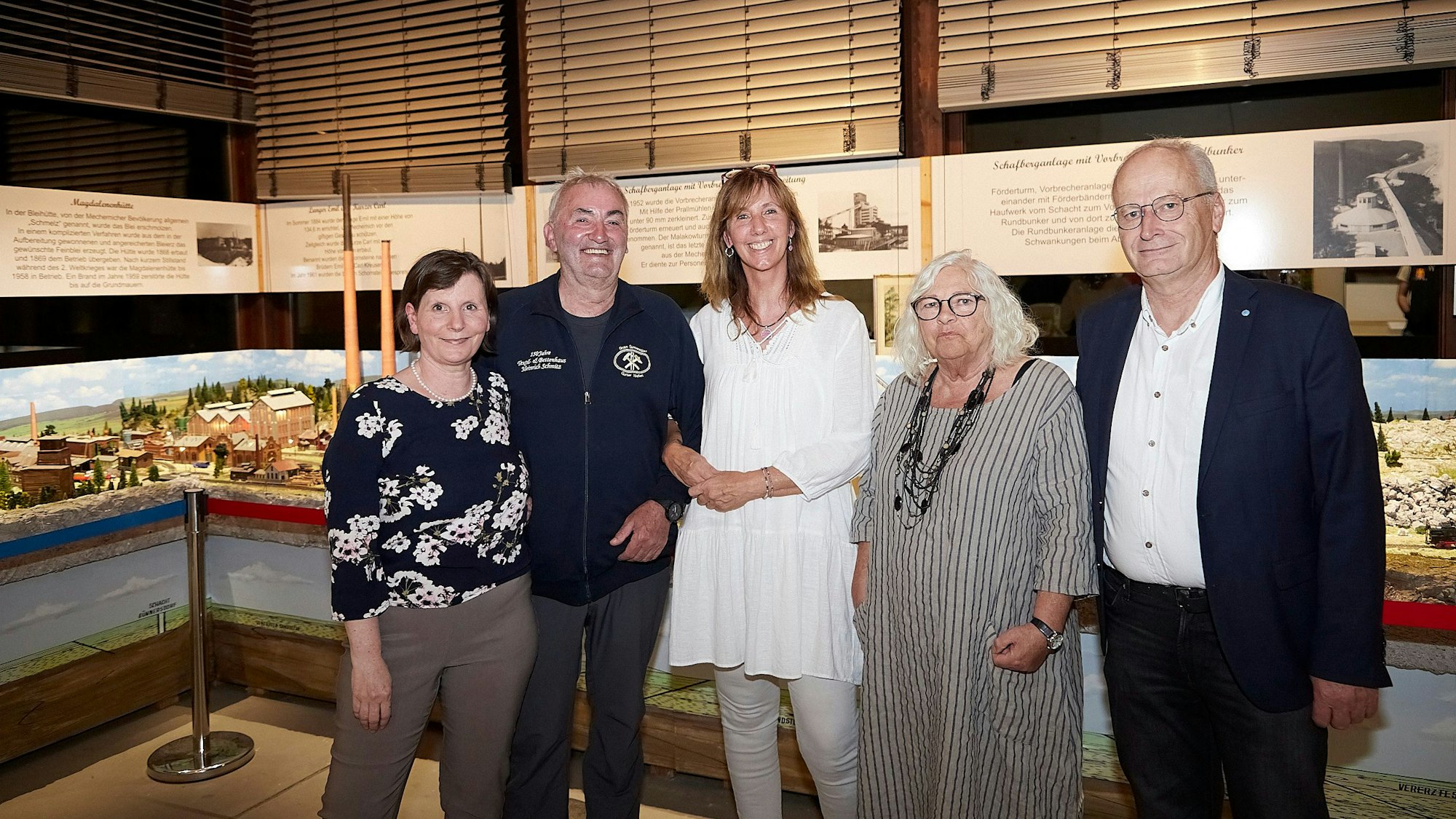 Zwei Männer und drei Frauen, Petra Hansen (v.l.), Günter Nießen, Ela Rübenach, Donata Reinhard und Hans-Peter Schick, stehen in einem Raum des Mechernicher Bergbaumuseum vor einem Modell des Bleibergwerks, das es bis 1957 in der Stadt gab.