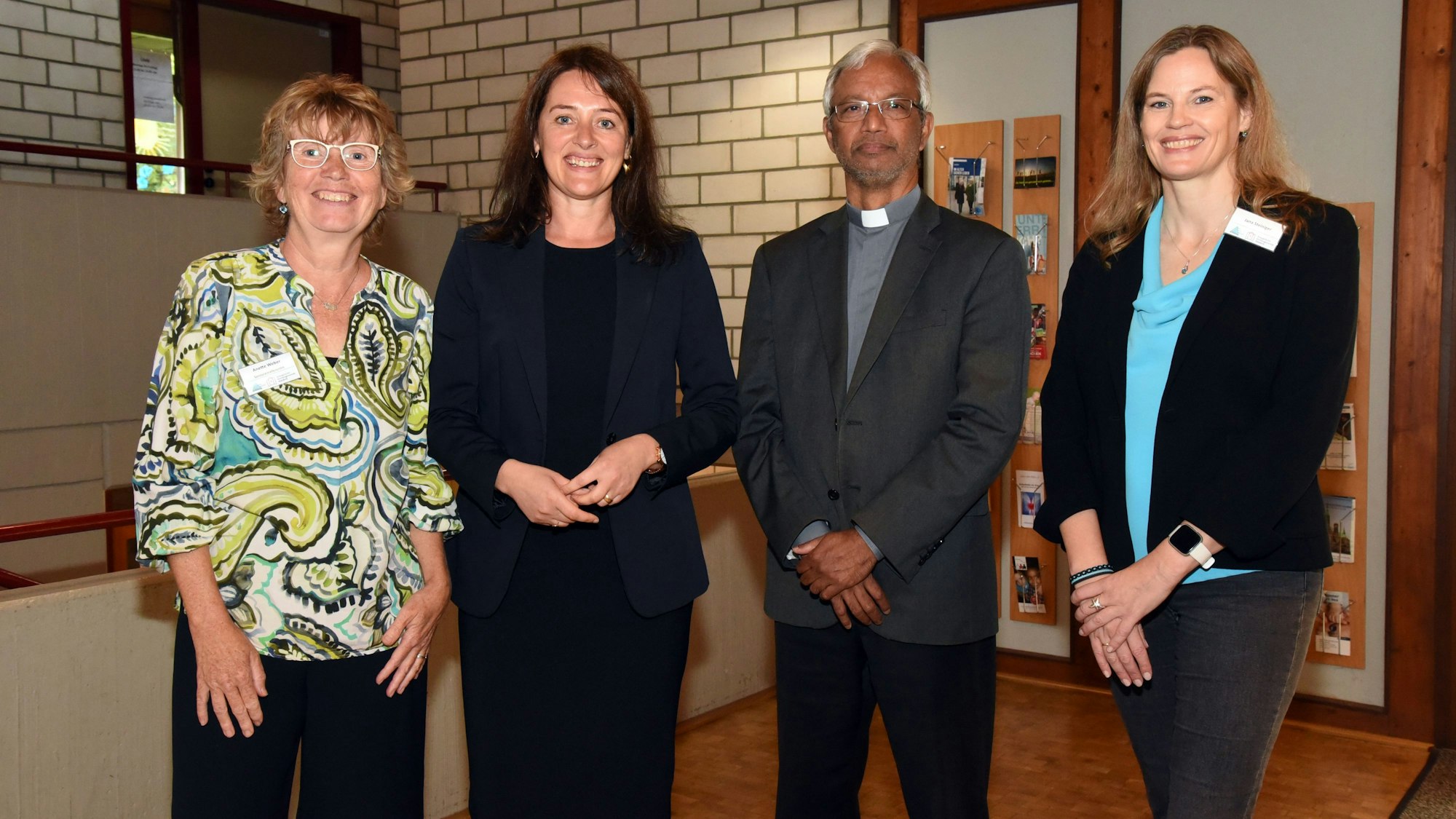 Drei Frauen und ein Pastor stehen in einer Reihe nebeneinander.