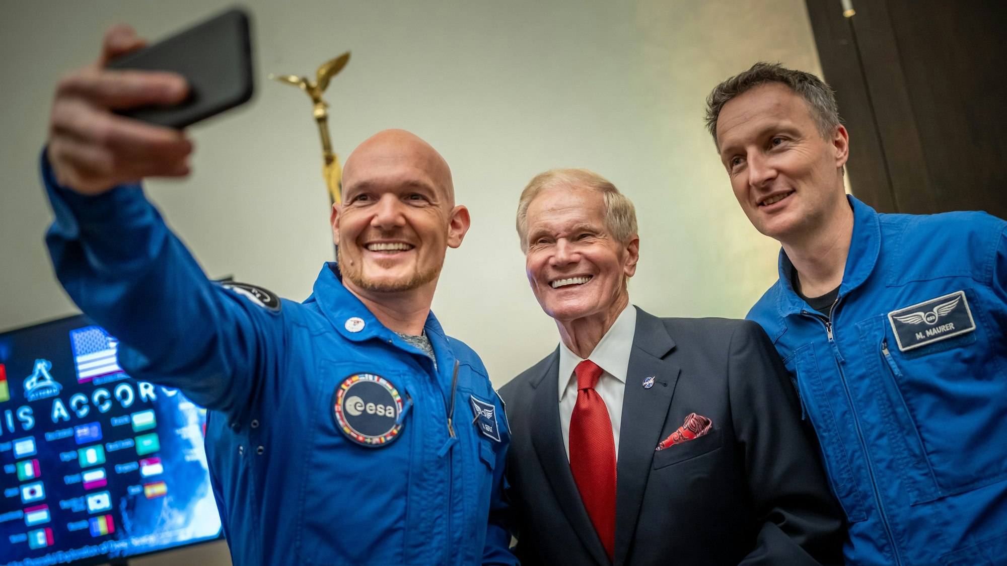 14.09.2023, USA, Washington: Die deutschen Astronauten Alexander Gerst (l) und Matthias Maurer (r) machen ein Selfie mit Bill Nelson, Chef der NASA, bei der Unterzeichnung des Beitritts Deutschlands zum Raumfahrtprogramm Artemis. Beim Artemis Accord haben sich zahlreiche Länder verpflichtet, die US geführte Mond Mission 2025 zu unterstützen. Foto: Michael Kappeler/dpa +++ dpa-Bildfunk +++