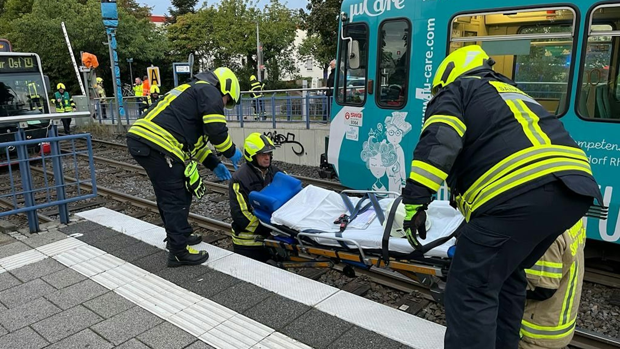 Rettungskräfte heben eine Trage aus dem Gleisbett in Sankt Augustin.