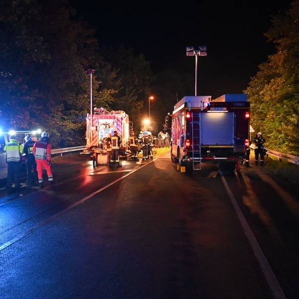 Auf einer Straße sind Rettungskräfte nach einem Unfall nachts im Einsatz.