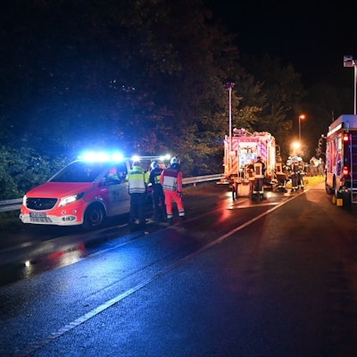 Auf einer Straße sind Rettungskräfte nach einem Unfall nachts im Einsatz.