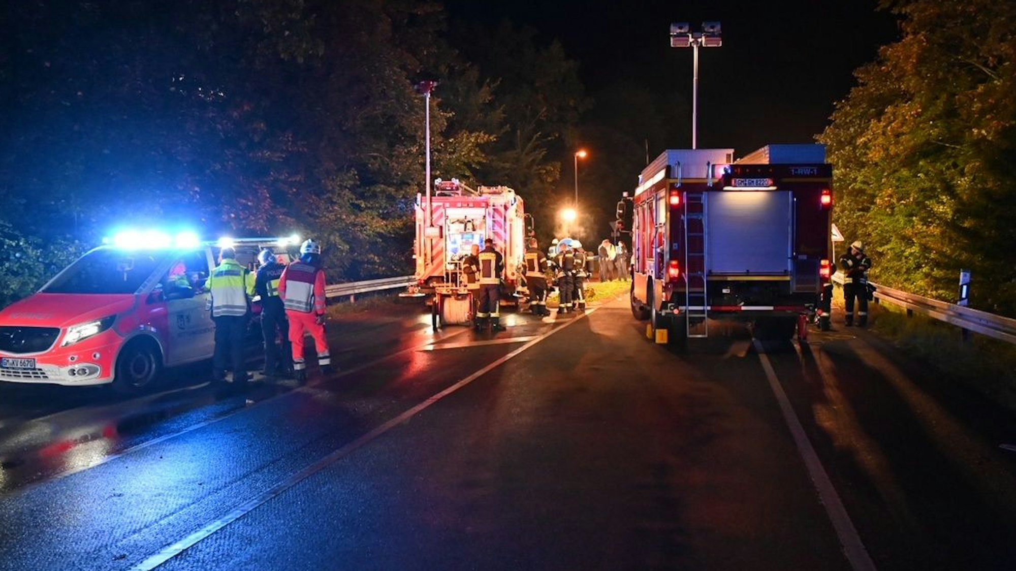 Auf einer Straße sind Rettungskräfte nach einem Unfall nachts im Einsatz.