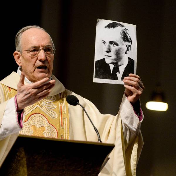 Der Geistliche Helmut Moll spricht in der Euskirchener Herz-Jesu-Kirche über Willi Graf und hält ein Foto in der Hand, das den Widerstandskämpfer zeigt.