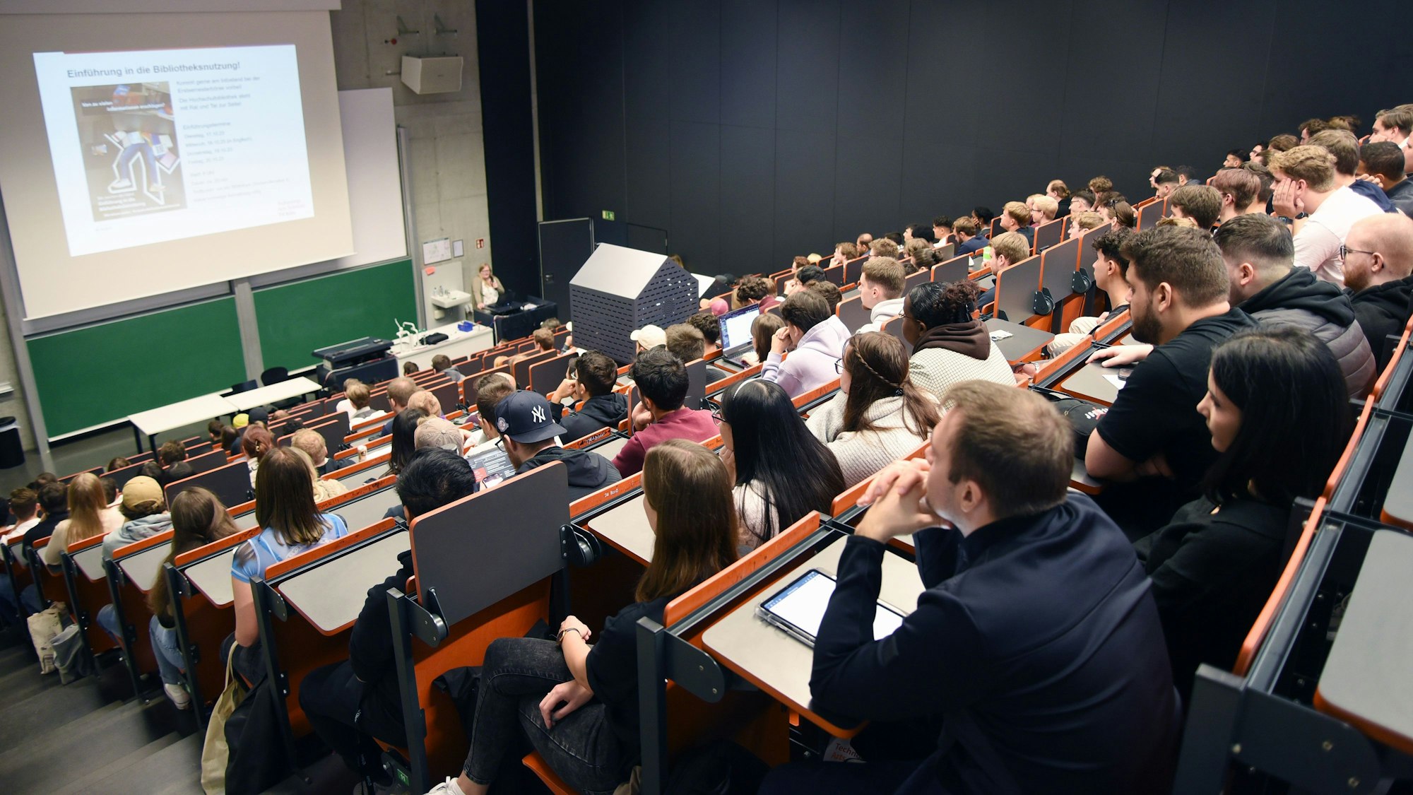 Erstsemester sitzen in einem großen Hörsaal einer Hochschule.