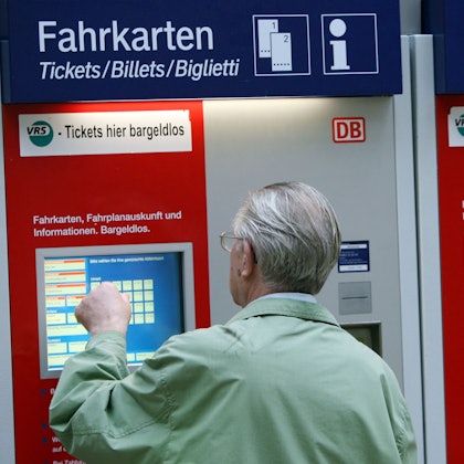 Ein Mann steht in Köln vor einem Fahrkartenautomaten der Bahn. (Archivbild)