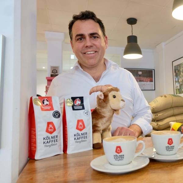 Kaffeeröster Gregor Hempsch steht an einem Tisch mit Kaffee.
