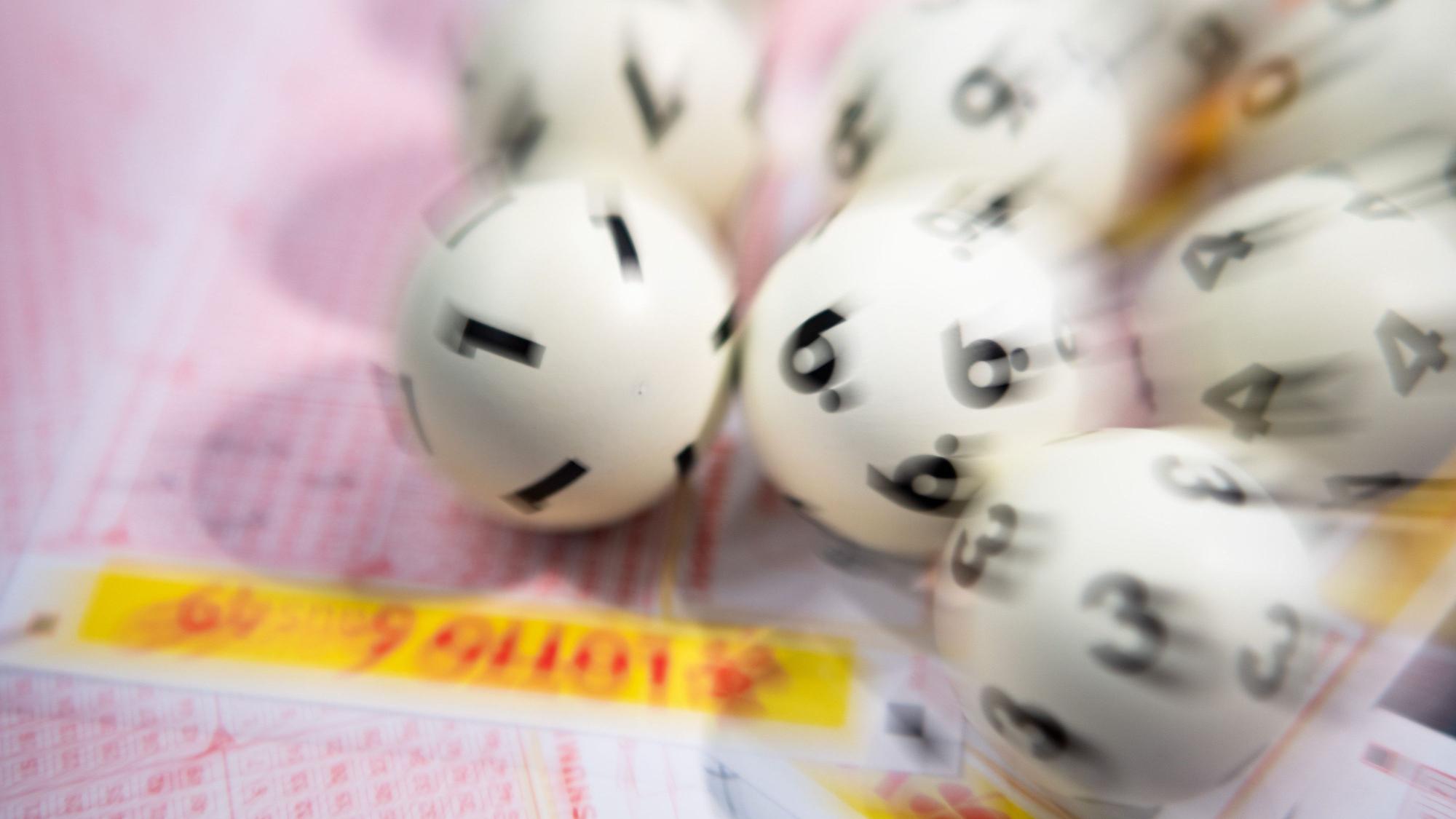 Lotto-Kugeln liegen auf einem Lottoschein.