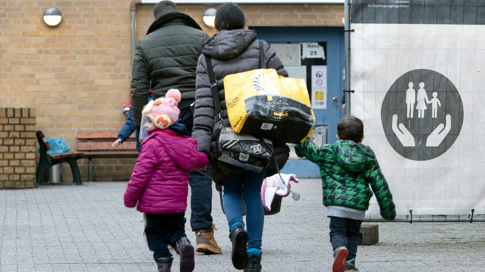 ARCHIV - 22.12.2022, Berlin: Eine geflüchtete Familie geht über das Gelände der Erstaufnahmeeinrichtung des Landesamtes für Flüchtlingsangelegenheiten (LAF) in Reinickendorf.