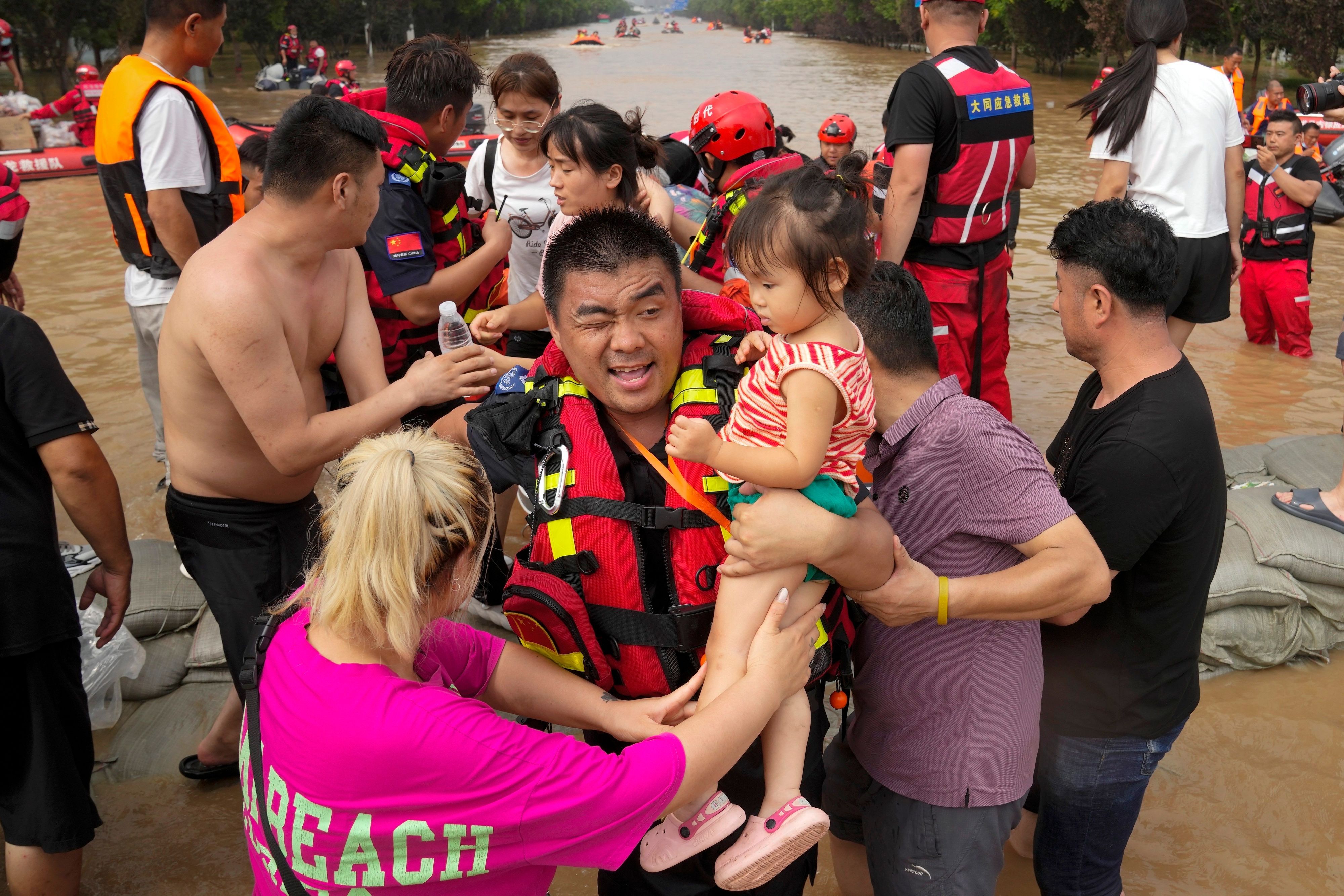 Rettungskräfte evakuieren eingeschlossene Bewohner durch die Fluten in der nordchinesischen Provinz Hebei.
