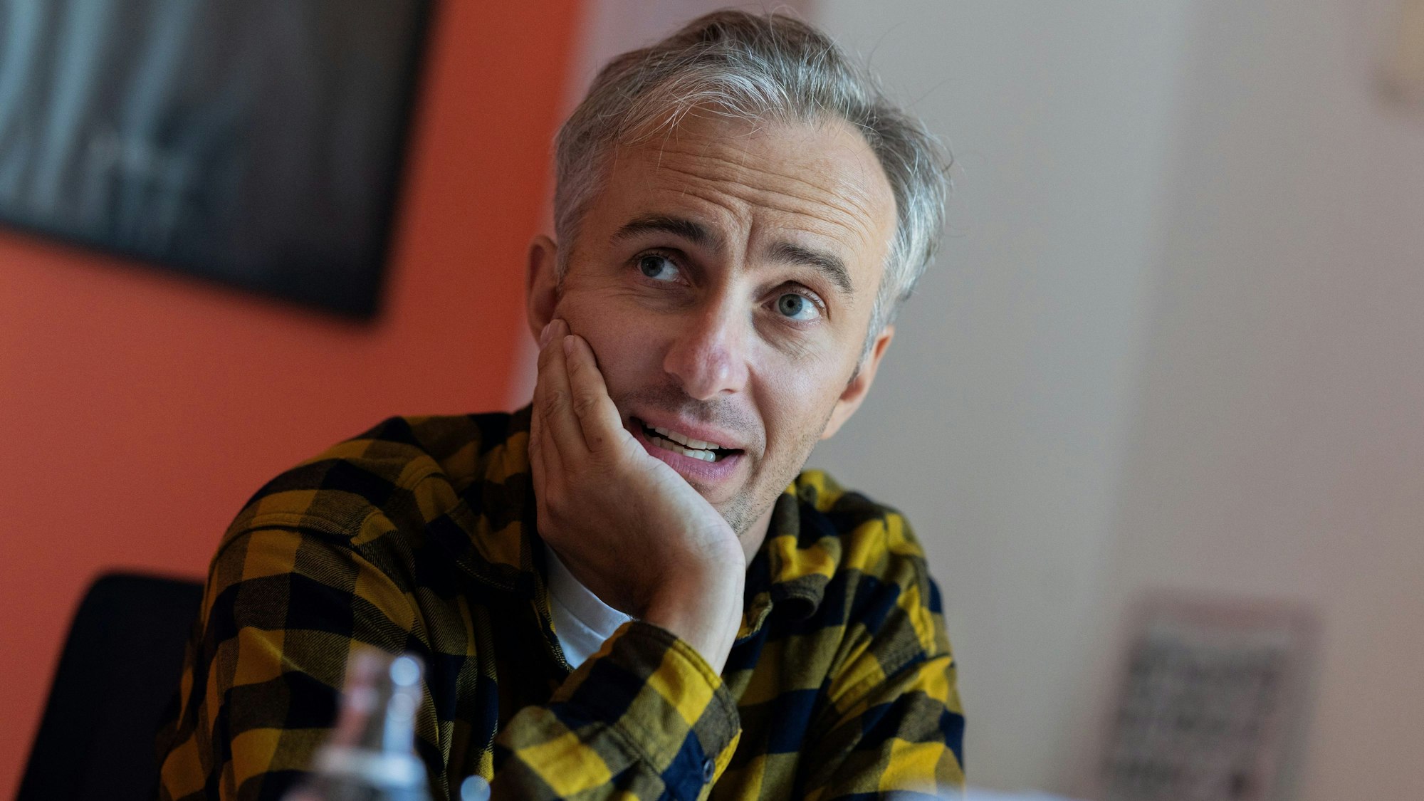 Der Moderator und Satiriker Jan Böhmermann sitzt während eines Interviews an einem Schreibtisch. Böhmermann moderiert das „ZDF Magazin Royale“.