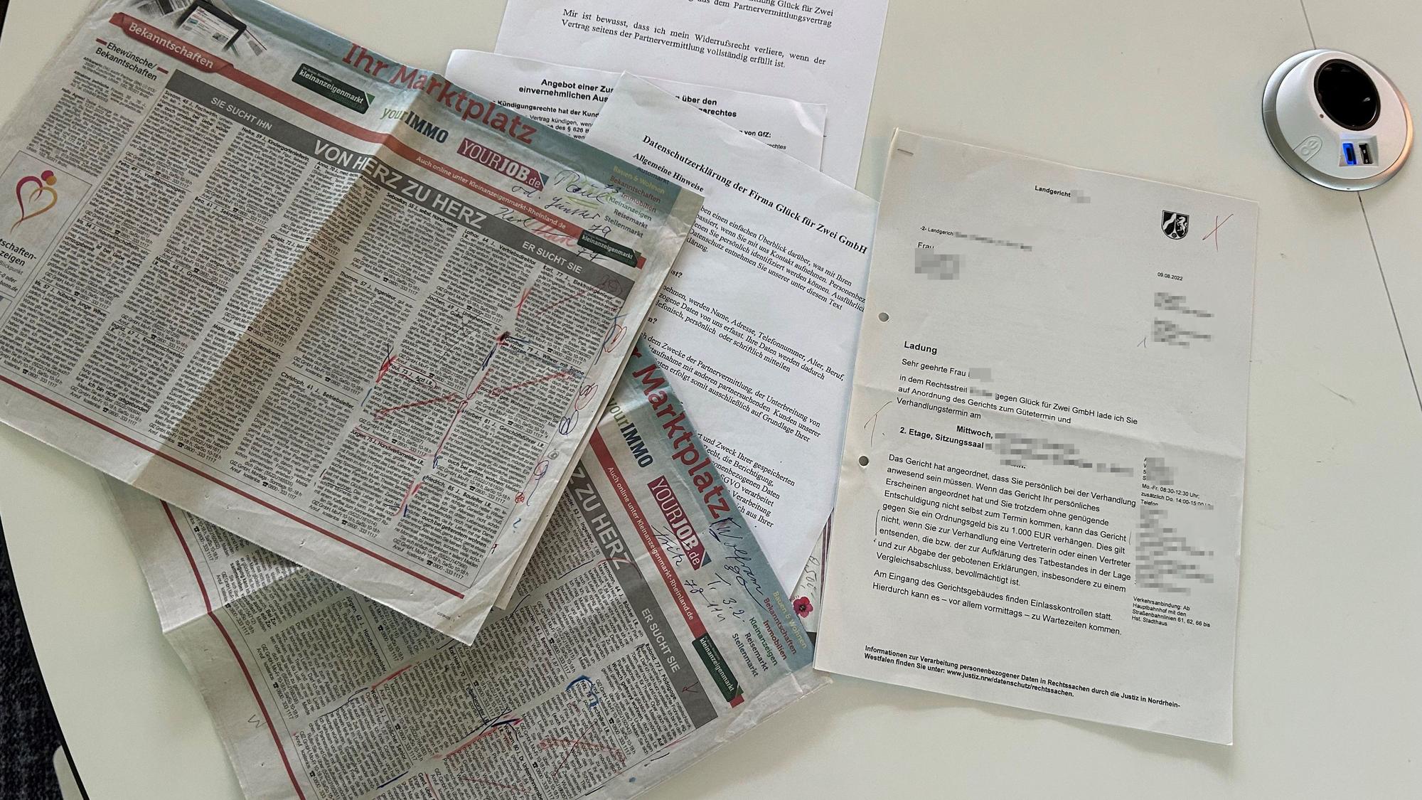 Die Zeitungsseite und die Unterlagen aus dem Rechtsstreit mit der Glück für Zwei GmbH.