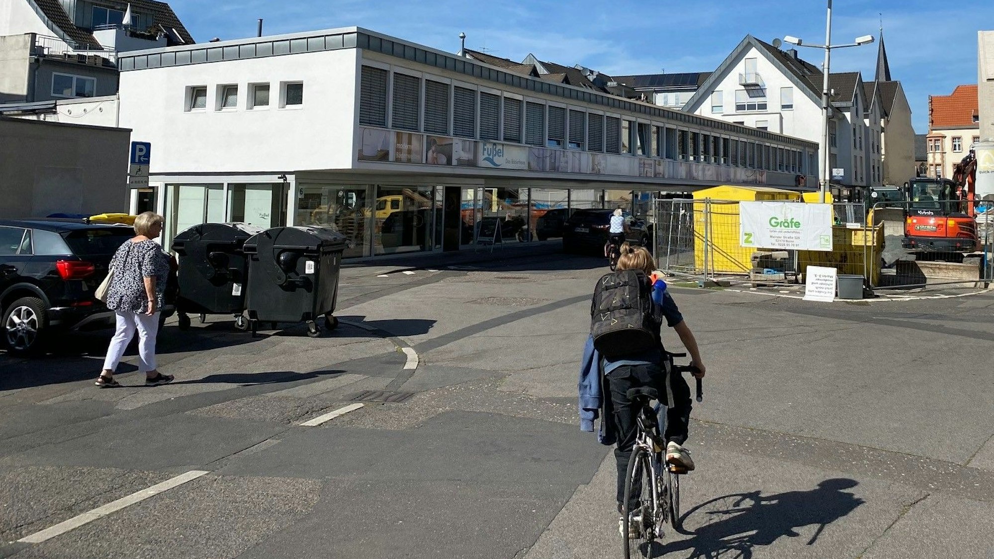 Ein Radfahrer fährt über den Platz, auf dem Baugeräte stehen.
