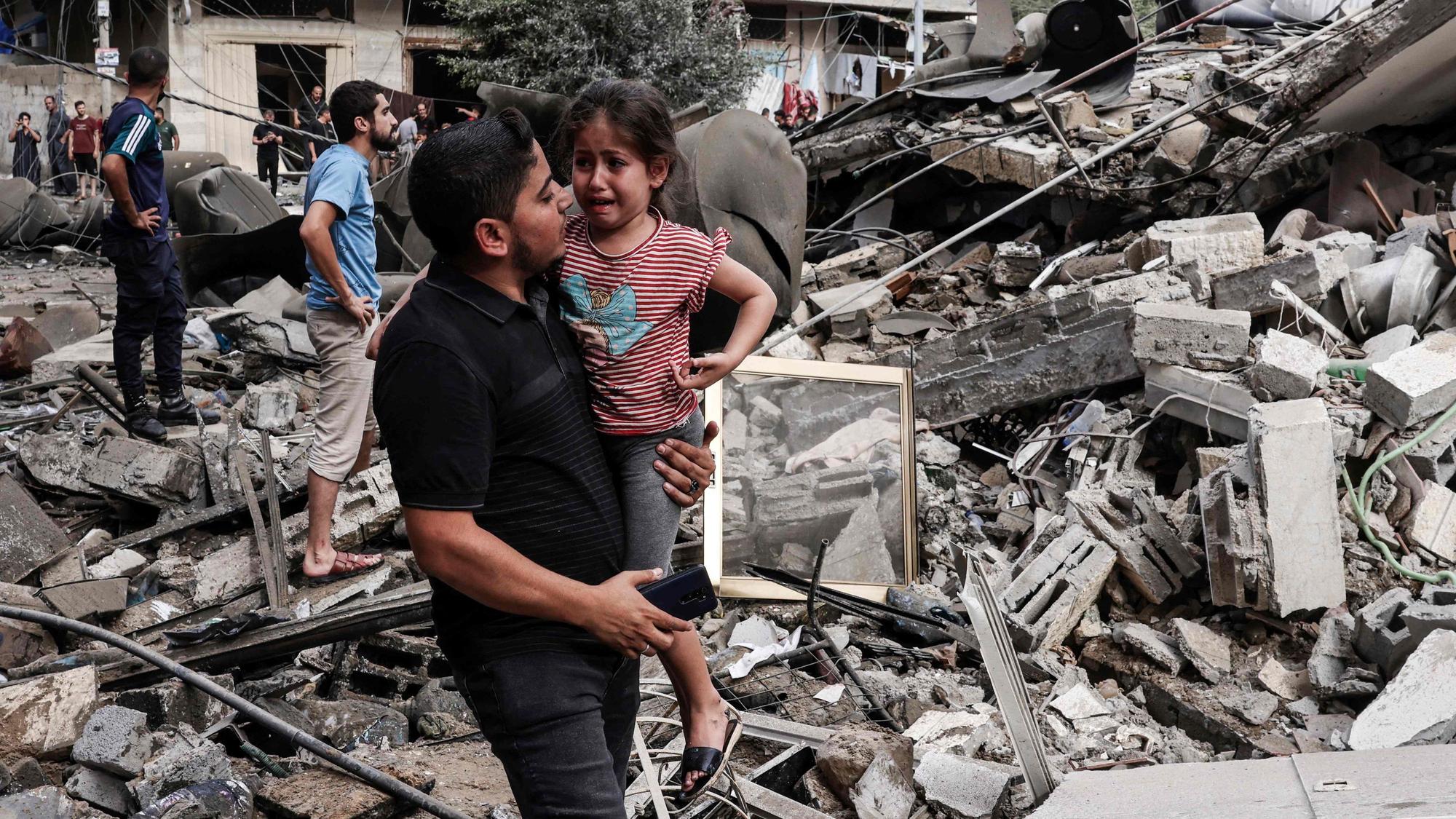 Ein Mann trägt ein Kind nach dem Gegenschlag der israelischen Luftwaffe im Gaza-Streifen. Der Terror der Hamas ruft Reaktionen Israels hervor, die Folge sind auch viele zivile Opfer.