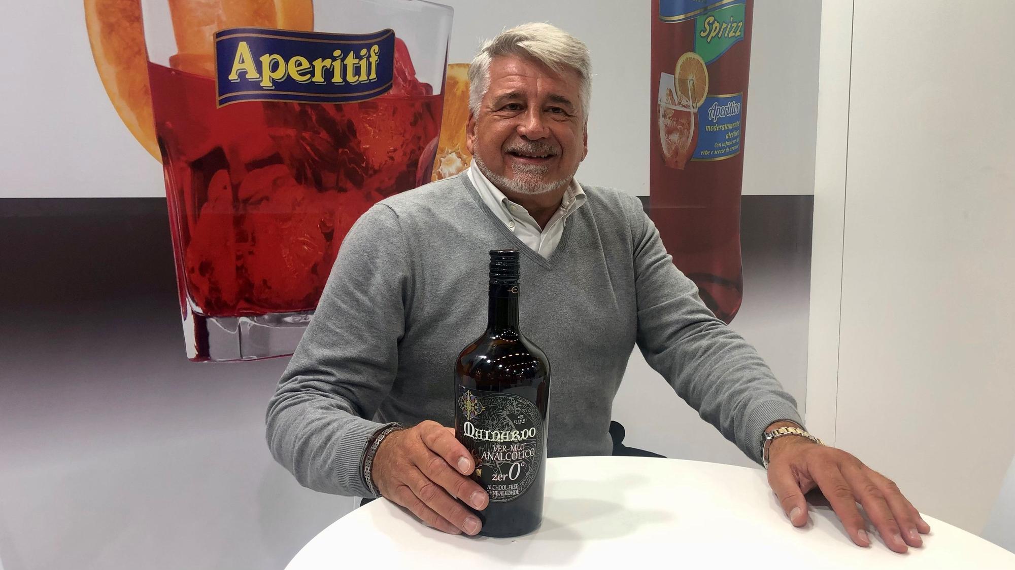 Grauhaariger Mann präsentiert einen alkoholfreien Vermouth