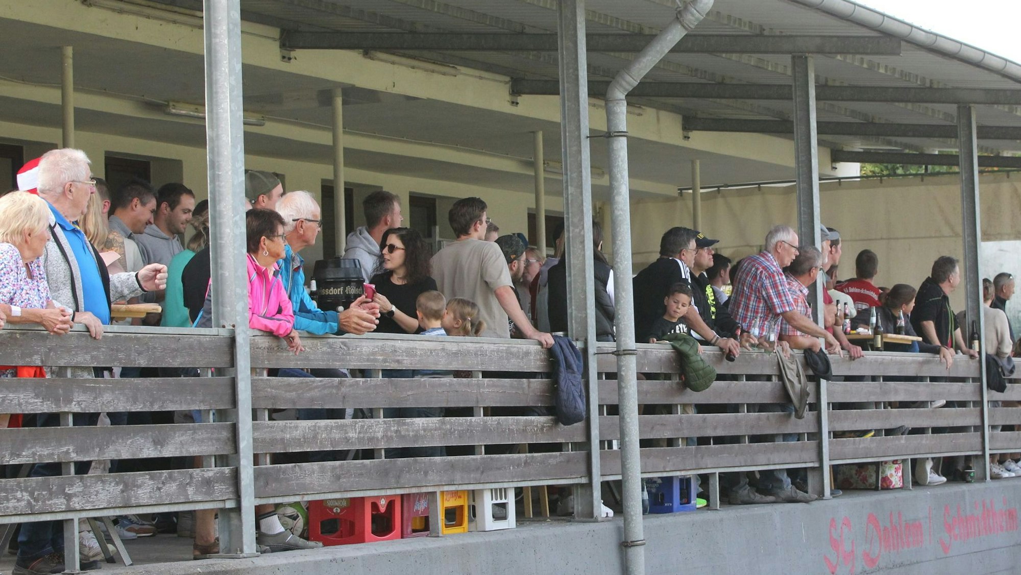 Zuschauer eines Fußball-Spiels stehen auf der Tribüne.