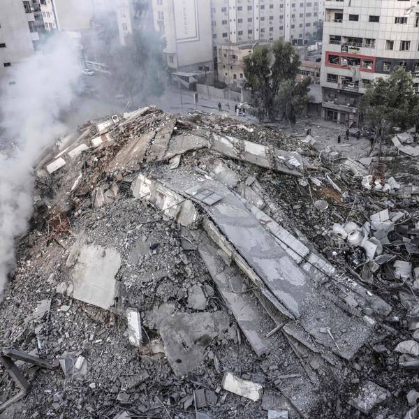 TOPSHOT - People walk around the ruins of a building destroyed in Israeli airstrikes in Gaza City on October 8, 2023. Fighting between Israeli forces and the Palestinian militant group Hamas raged on October 8, with hundreds killed on both sides after a surprise attack on Israel prompted Prime Minister Benjamin Netanyahu to warn they were "embarking on a long and difficult war". (Photo by Mohammed ABED / AFP)