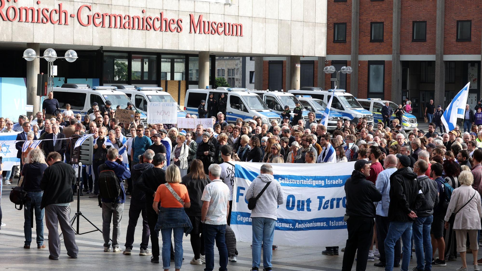 Israel-Unterstützer schwenken Fahnen und ein Transparent bei einer Kundgebung auf dem Roncalliplatz.