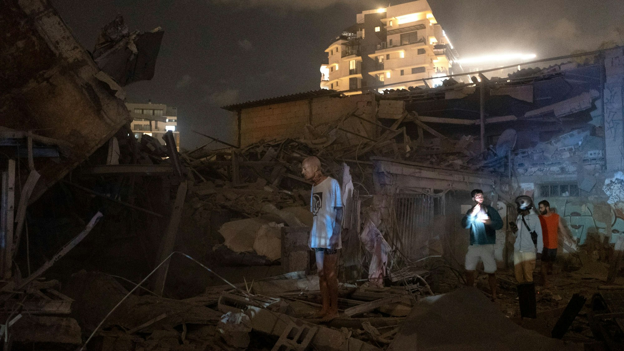 Menschen betrachten die Schäden einer aus dem Gazastreifen abgefeuerten Rakete in Tel Aviv.