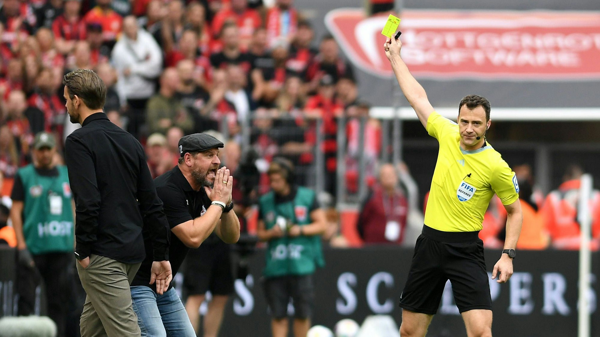 Schiedsrichter Felix Zwayer zeigt Trainer Steffen Baumgart die Gelbe Karte.