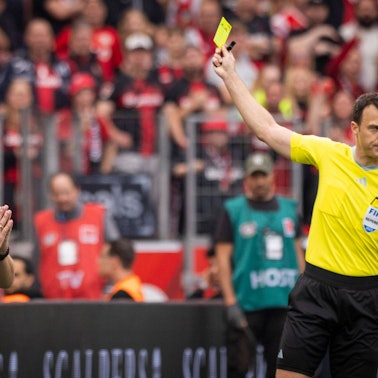 Schiedsrichter Felix Zwayer zeigt Trainer Steffen Baumgart Gelb wegen Meckerns.