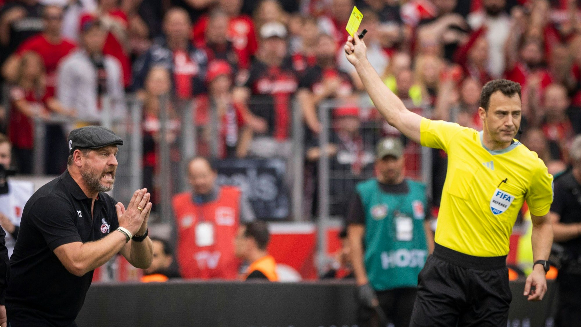 Schiedsrichter Felix Zwayer zeigt Trainer Steffen Baumgart Gelb wegen Meckerns.